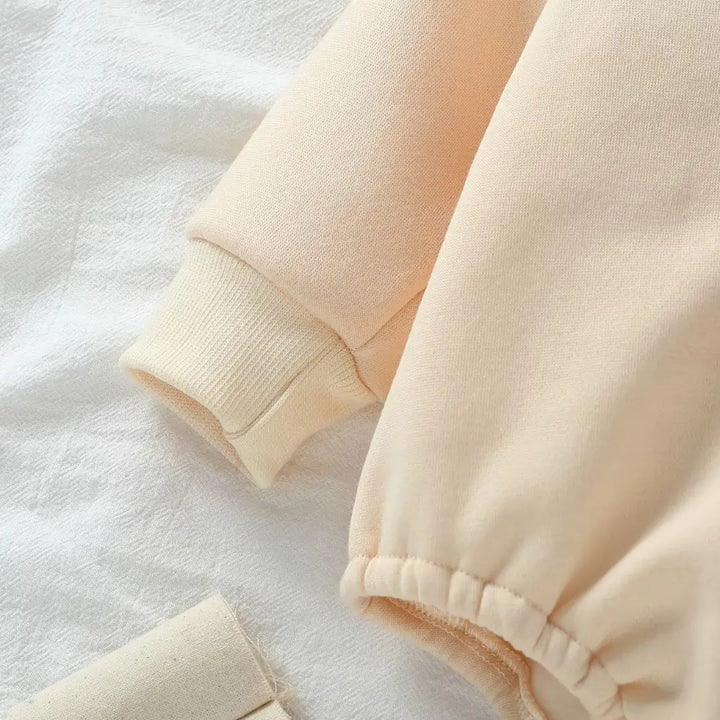 Manga e punho do body bege CozyNest, moletinho macio ThermoSoft™ para dias frios.