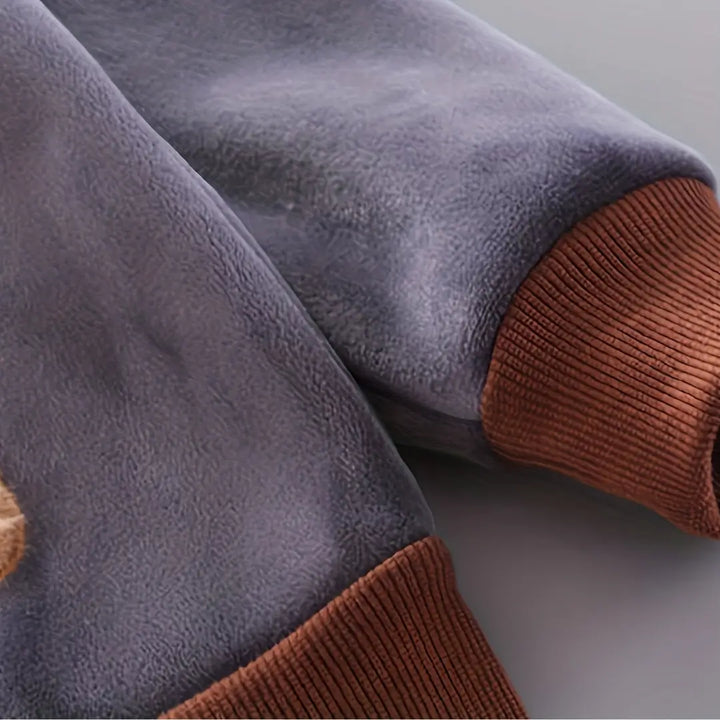 Manga do moletom Marrom Cacau com punho canelado, textura do tecido aveludado.