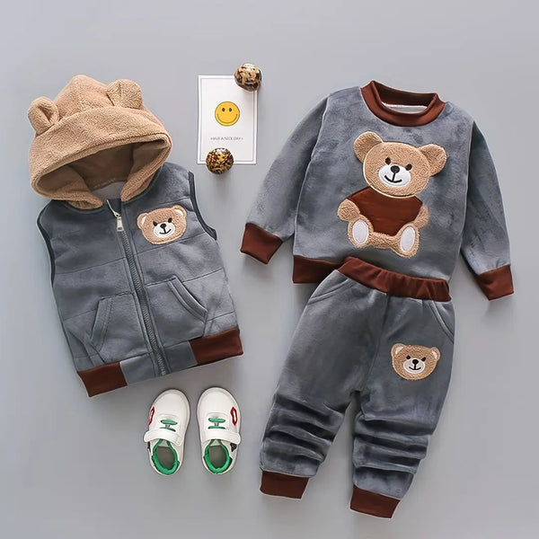 Conjunto Abraço de Urso Marrom Cacau em flat lay com tênis, moletom, colete com capuz e calça.