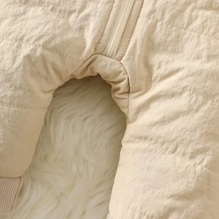 Abertura com zíper até o entrepernas do Macacão de Bebê Bege SoftHug™ para facilitar a troca.