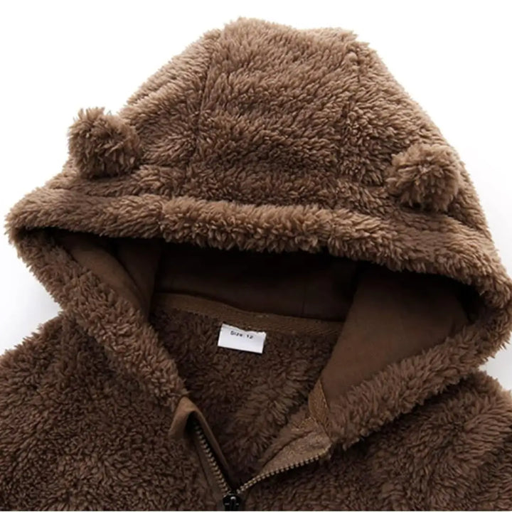 Detalhe do capuz do macacão Teddy Cozy Marrom Avelã Materna Kid, interior aveludado e forro térmico.