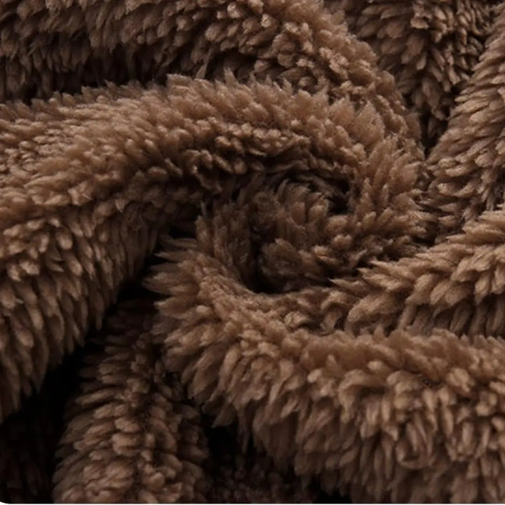 Textura do tecido SoftHug™ do macacão Teddy Cozy Marrom Avelã Materna Kid, pelúcia densa e aconchegante.