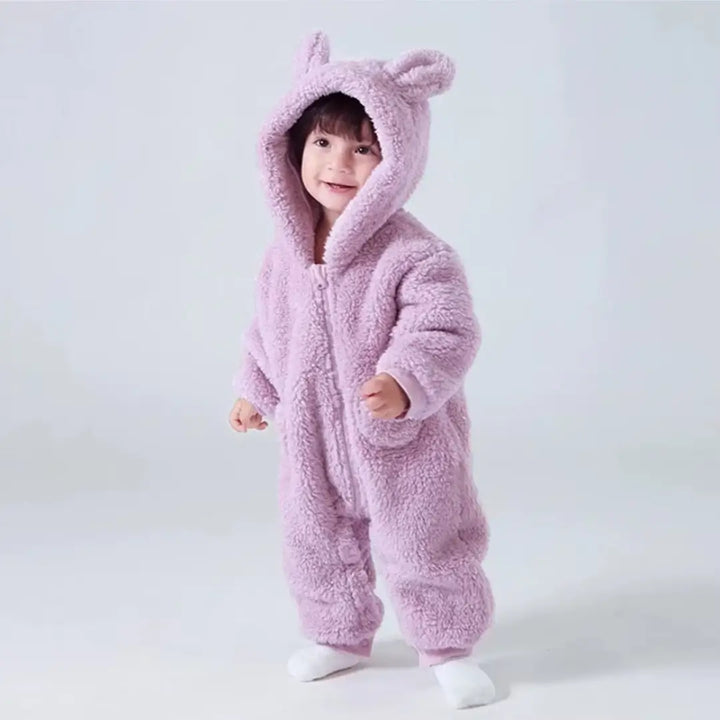 Bebê em pé vestindo o macacão Teddy Luna Lavanda Materna Kid, design fofo e pelúcia SoftHug™ ideal para o inverno