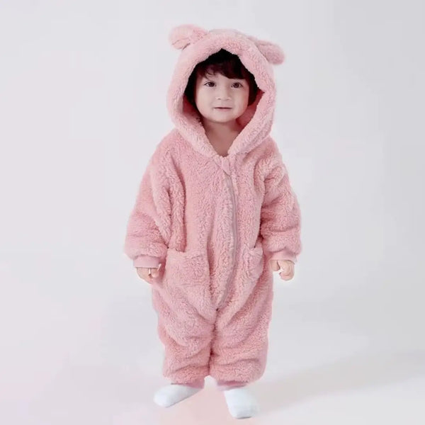 Bebê sorridente com o macacão Teddy Luna Ouro Rosa Materna Kid, pelúcia SoftHug™ aveludada que garante aconchego e estilo