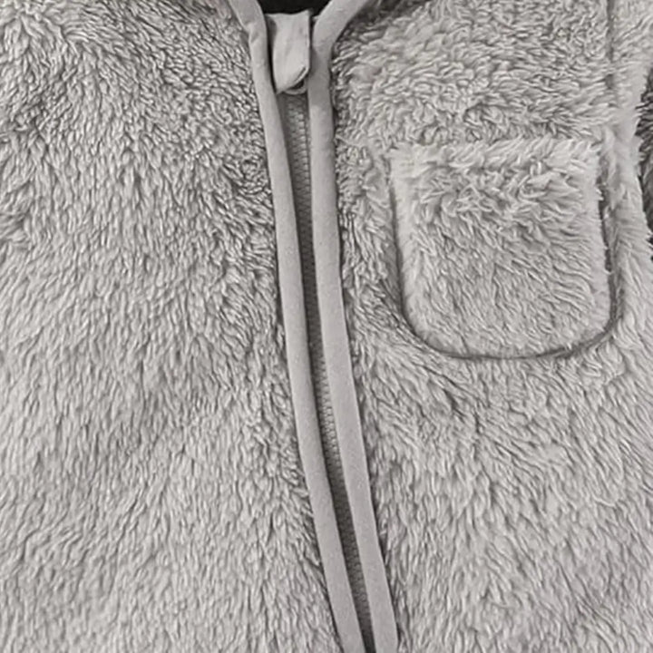 Detalhe do bolso do macacão Teddy Sky Cinza Nuvem Materna Kid, mostrando textura SoftHug™.